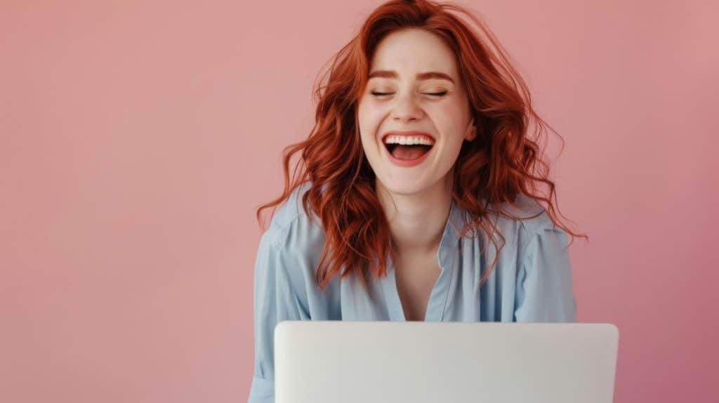 Femme souriante devant un ordinateur portable, illustrant l'importance de l'humour dans l'écriture professionnelle.